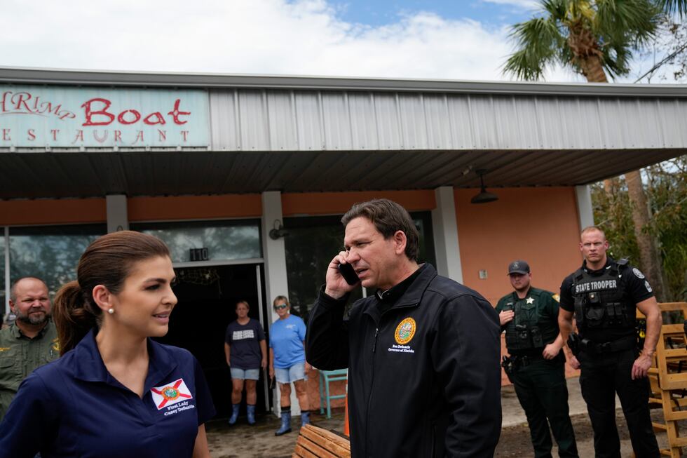 FILE - Florida Gov. Ron DeSantis talks on the phone with President Joe Biden, as he and wife...