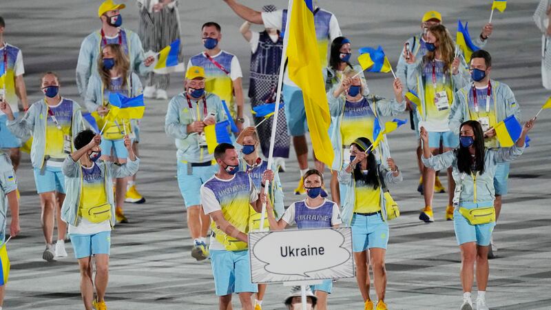FILE - Olena Kostevych and Bogdan Nikishin, of Ukraine, carry their country's flag during the...