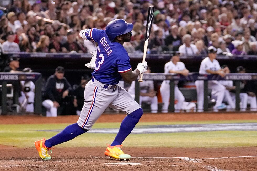 Texas Rangers' Adolis Garcia grabs his left side after his swing during the eighth inning in...