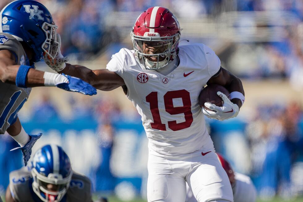 Alabama wide receiver Kendrick Law (19) stiff arms Kentucky defensive back Ty Bryant (14)...
